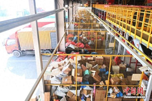 2月初,兰州市一快递物流转运中心内,工作人员进行分拣装车工作。 李亚龙 摄